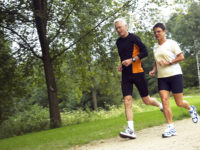 Senior Couple Running In The Woods