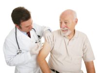 Senior man getting a flu shot from his doctor.  Isolated