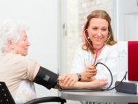 doctor measuring blood pressure of senior patient