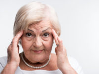 Elderly lady touching her head with fingers