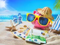 Piggy bank with sunglasses relax on the beach holiday